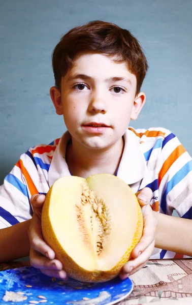Preteen handsome boy with ripe cutted  melon — Stock Photo, Image