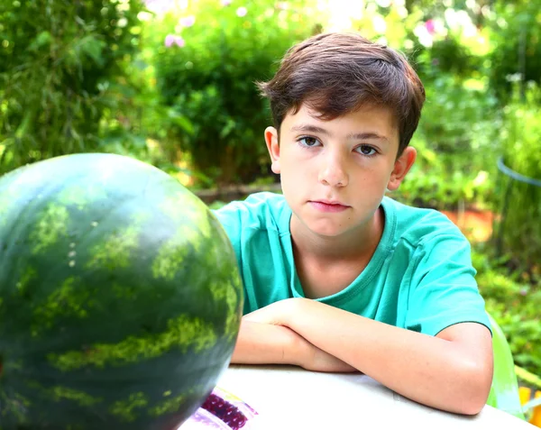 Pojke med vatten melon skiva på sommar trädgård bakgrund — Stockfoto