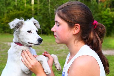 Kız oyun ile yaz orman arka plan üzerinde beyaz köpek yavrusu