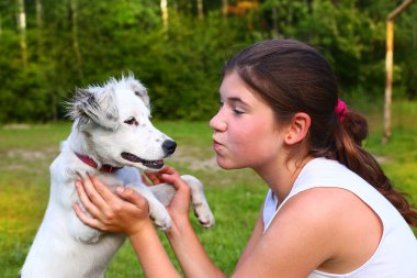  Kız oyun ile yaz orman arka plan üzerinde beyaz köpek yavrusu