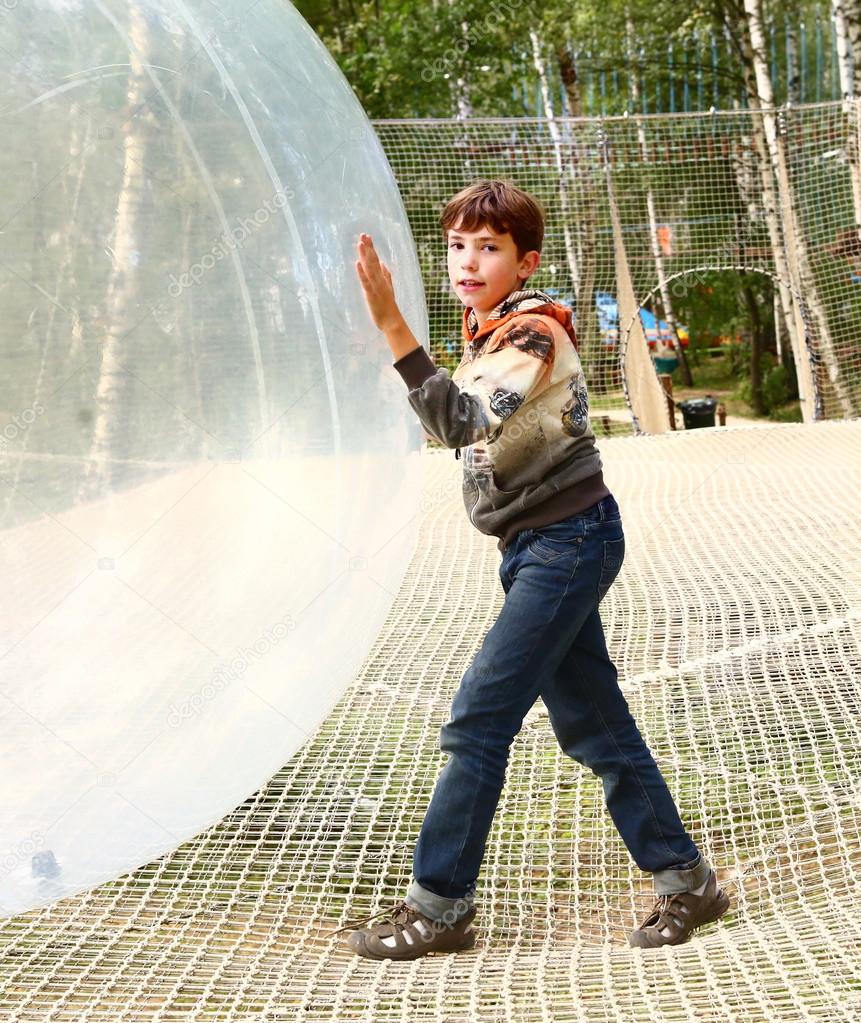 preteen boy play huge ball in outdoor sport open air activity park