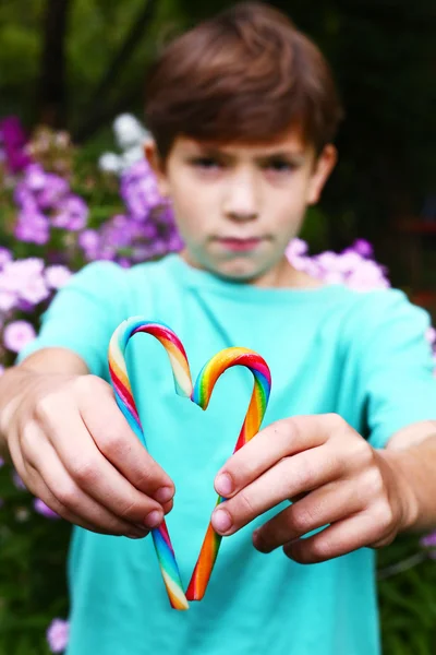 Garçon préadolescent avec bâtonnets de bonbons arc-en-ciel — Photo