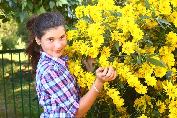 10 代の少女の国は大きな黄色の花を持つ肖像画を間近します。 — ストック写真