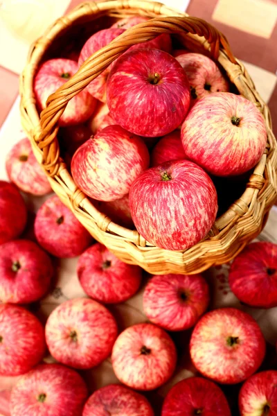 Maçãs vermelhas maduras frescas na cesta na mesa — Fotografia de Stock