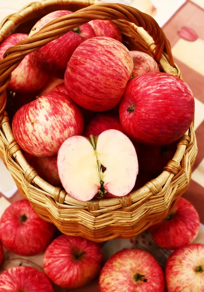 Maçãs vermelhas maduras frescas cortadas na cesta na mesa — Fotografia de Stock