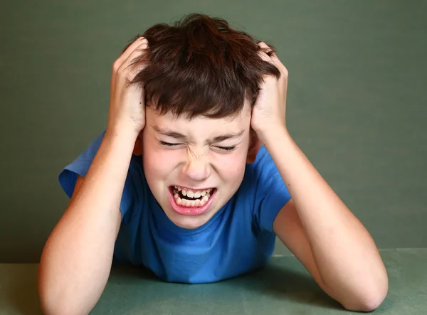 Junge kratzt seinen Kopf isoliert auf blauem Grund — Stockfoto