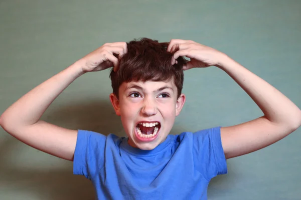 Boy scratch his head isolated on blue — Stock Photo, Image