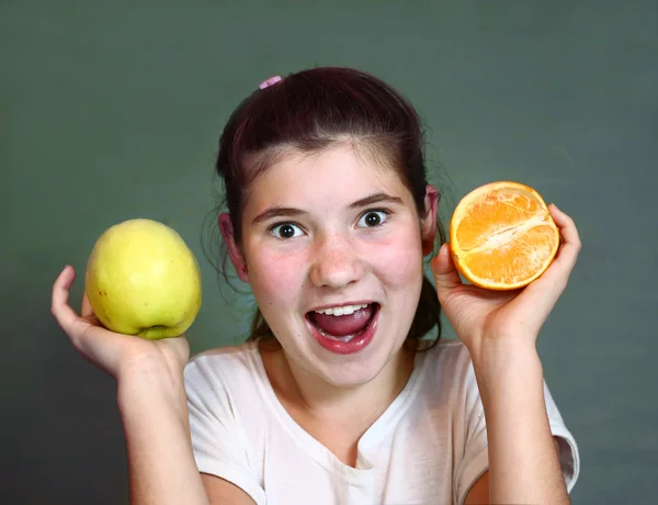 Meisje met sinaasappel en appel geïsoleerd op blauw — Stockfoto