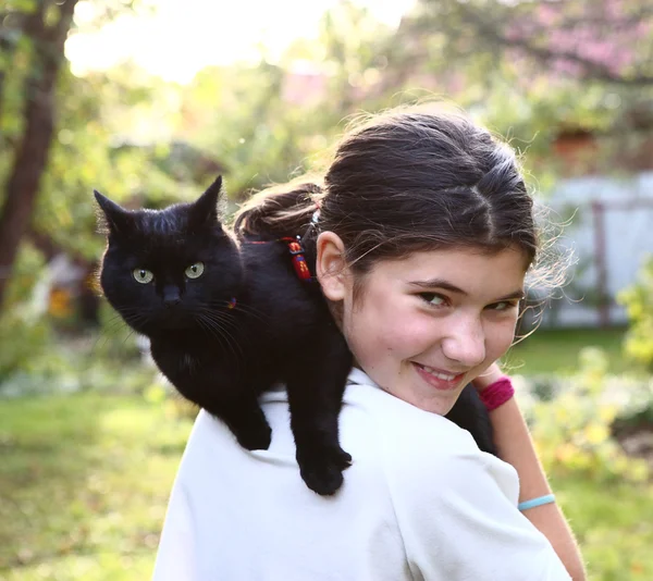 Chica en blanco camiseta hold negro gato en hombro —  Fotos de Stock