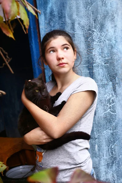 Meisje met zwarte vleermuis op blauwe deur achtergrond — Stockfoto