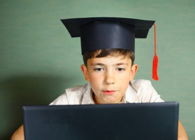 Not Defteri ile mezuniyet şapkalı çocuk
