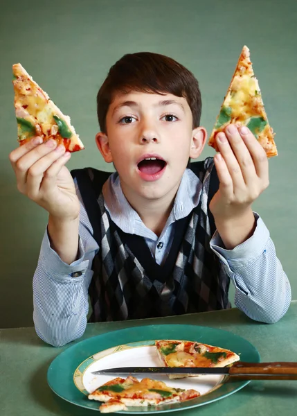 Menino com placa de pizza no fundo azul — Fotografia de Stock