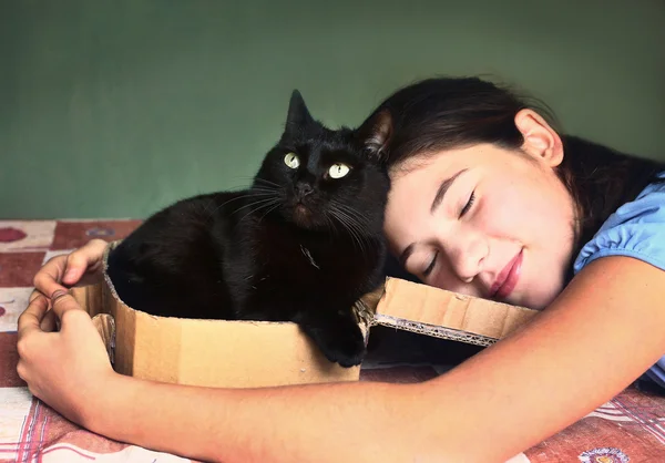 Девочка-подросток обнимает черную кошку крупным планом — стоковое фото