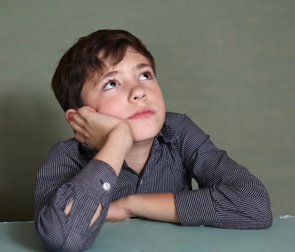 Stilig pojke funderar på blå vägg bakgrund — Stockfoto