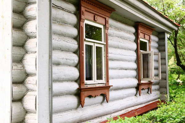 Casa da aldeia com bandejas de janela enfeites — Fotografia de Stock