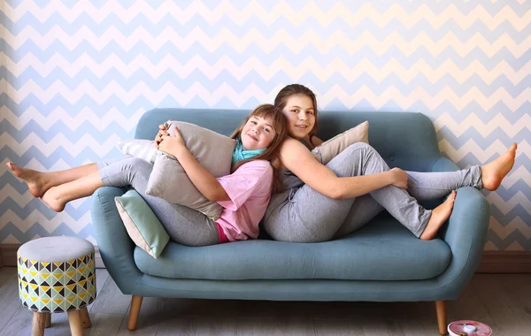 Teenager blond sister in pajamas on the sofa — Stock Photo, Image