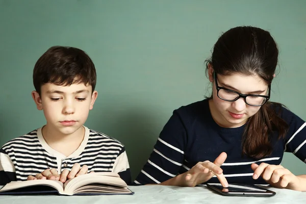 Menino ler livro menina jogar tablet jogos de computador — Fotografia de Stock