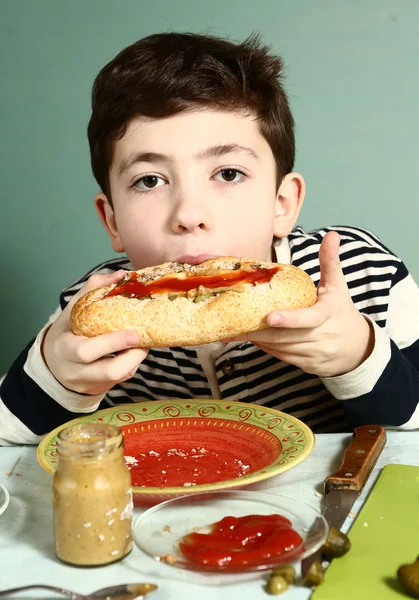 Jongen bijten zelf gemaakt enorme hotdog — Stockfoto