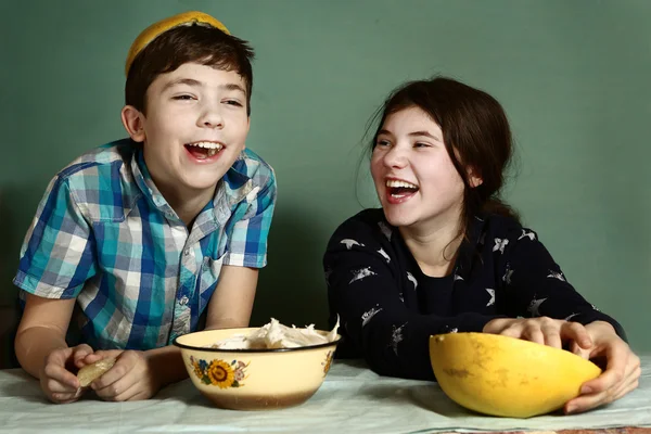 Kids  siblings  peeling grape fruit make funny hat — Stock Photo, Image