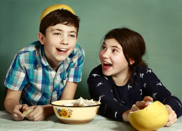 Děti sourozenci loupání hroznové ovoce, aby legračním klobouku — Stock fotografie