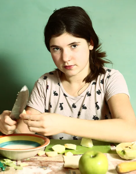 Ragazza lunghi capelli scuri preparare torte con mele tagliate — Foto Stock