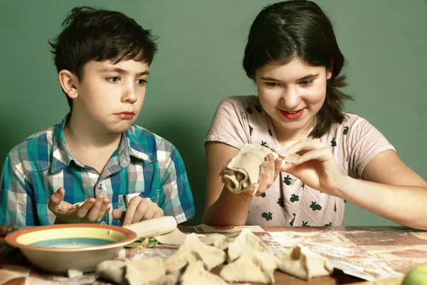 Schwester bringt Bruder Junge bei, wie man Apfelkuchen backt — Stockfoto