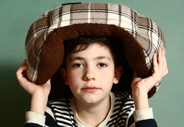 Boy put cat bed as a hat on his head — Stock Photo, Image