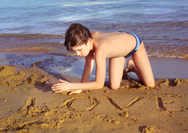 Menino na praia tomar banho de sol brincar com areia — Fotografia de Stock
