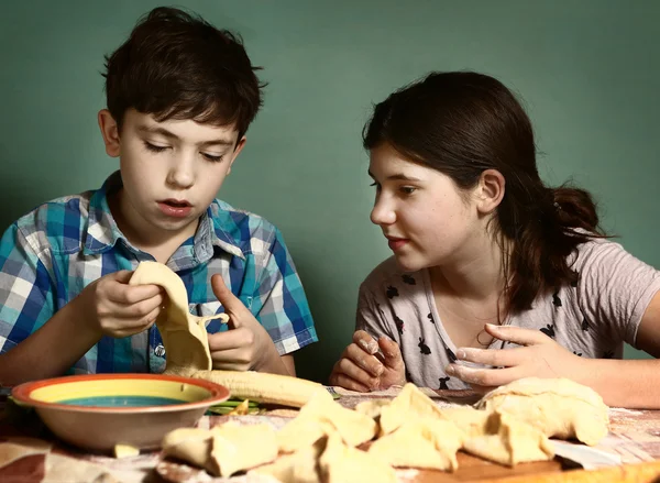 Sister teach brother boy how to bake apple pies — Stock Photo, Image