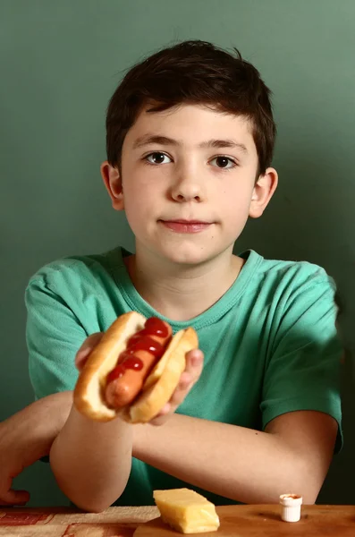 Adolescente bonito menino com cachorro quente — Fotografia de Stock