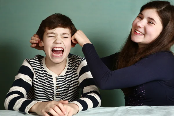 Hermana tire de su hermano orejas de niño debido a apuesta — Foto de Stock