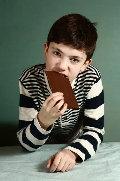 Gelukkig preteen jongen met de chocolade bar — Stockfoto