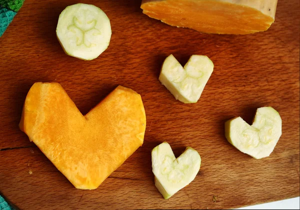 Cut pumpkin and courgette in heart form — Stock Photo, Image