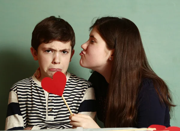 Niño y niña sostienen dos corazón de cartón rojo — Foto de Stock