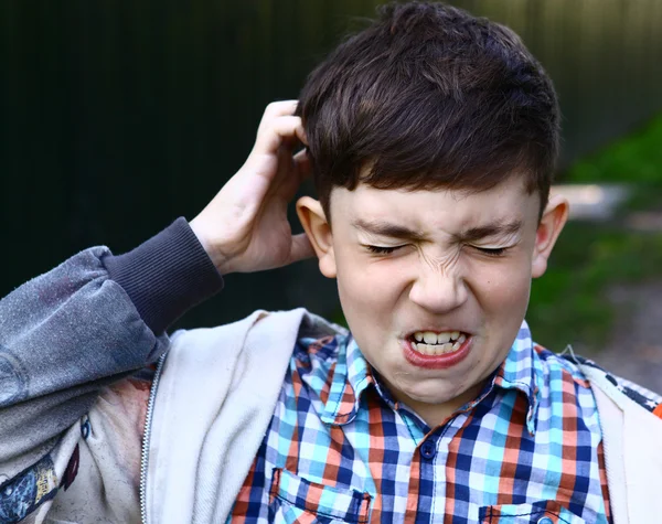 Preteen knappe jongen zijn hoofd krabben — Stockfoto