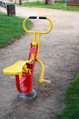 Açık spor salonundaki kırmızı ve sarı spor makinesi.