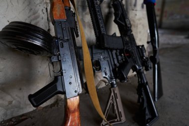 Makineli tüfek, tüfek, tüfek evin duvarına dayanıyor.