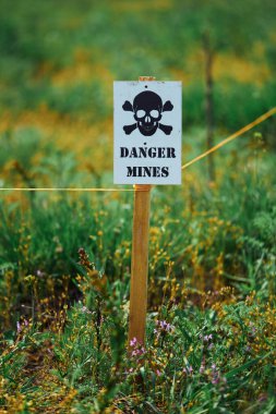 Mayın tarlasında tehlike uyarısı olan bir tabelanın yakın çekimi.