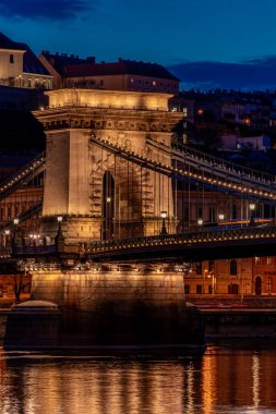 Budapeşte 'de alacakaranlık, Tuna Nehri üzerindeki zincir köprü, sudaki gece ışıklarının yansıması.