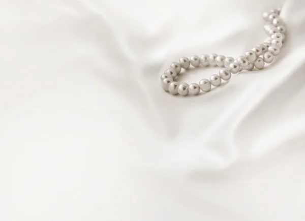 Beiger Hintergrund mit Seide und Perlen — Stockfoto