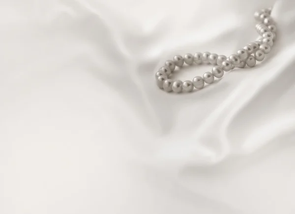 Beiger Hintergrund mit Seide und Perlen — Stockfoto
