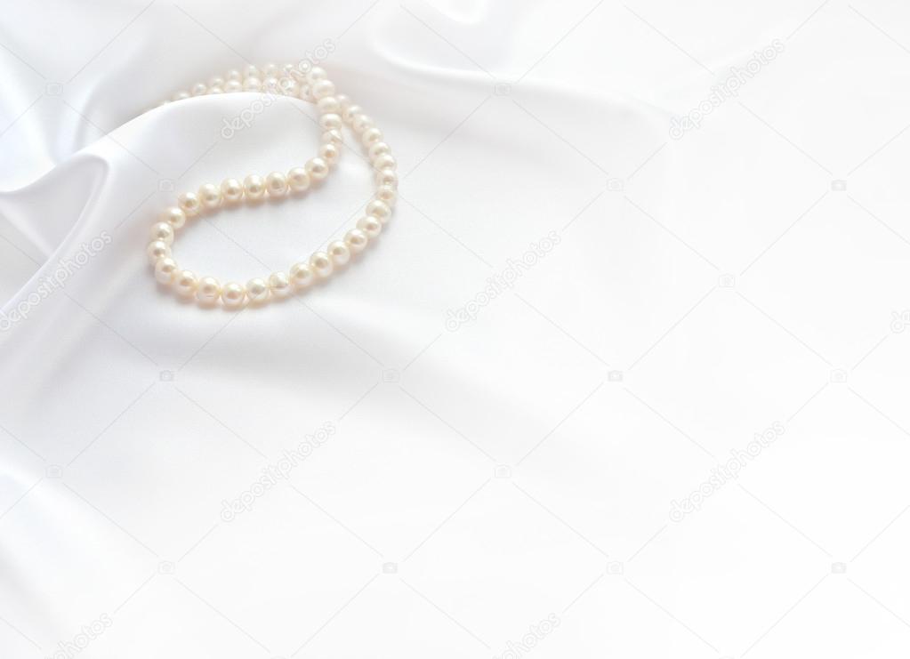 Elegant white background with lace, silk and pearls