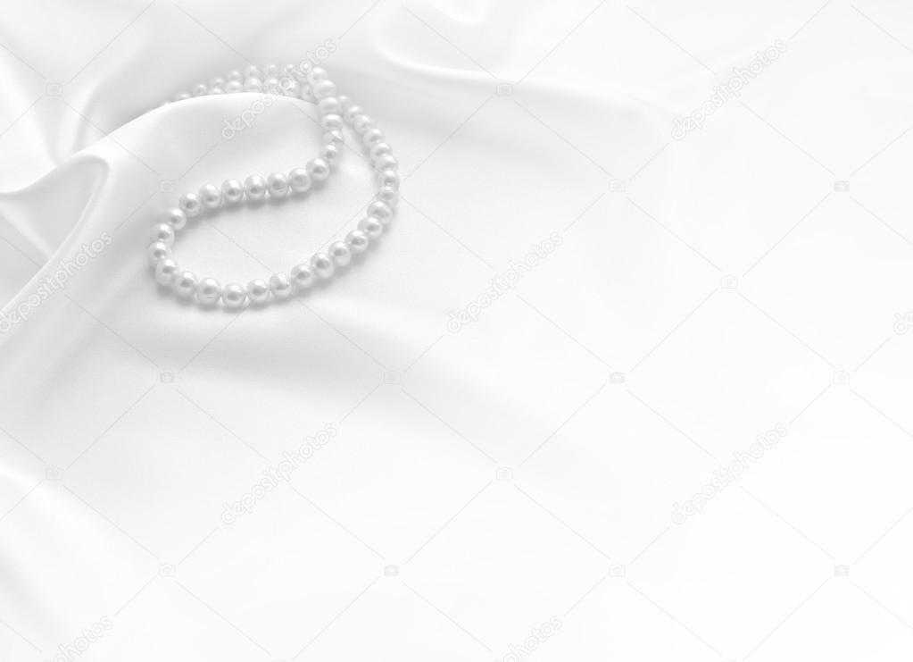 Elegant white background with lace, silk and pearls