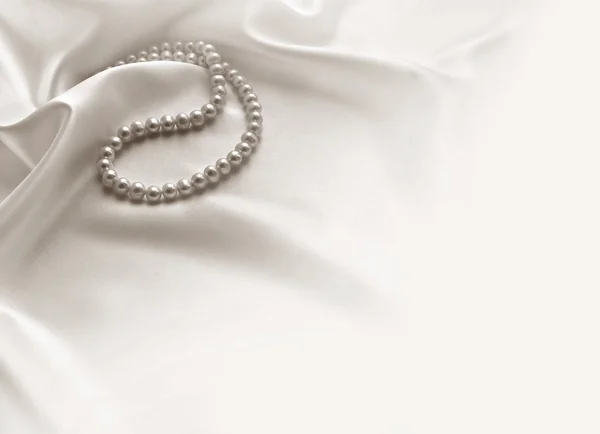 Elegantní bílé pozadí s krajky, hedvábí a perly — Stock fotografie