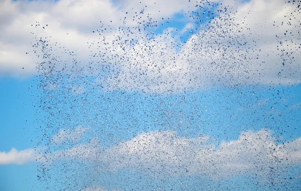 Gocce d'acqua contro un cielo blu con nuvole bianche , — Foto Stock