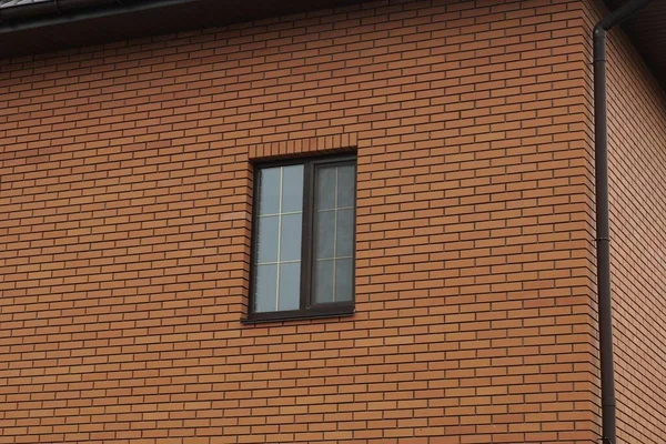 一幢建筑物的棕色砖墙上的一个大窗户 — 图库照片