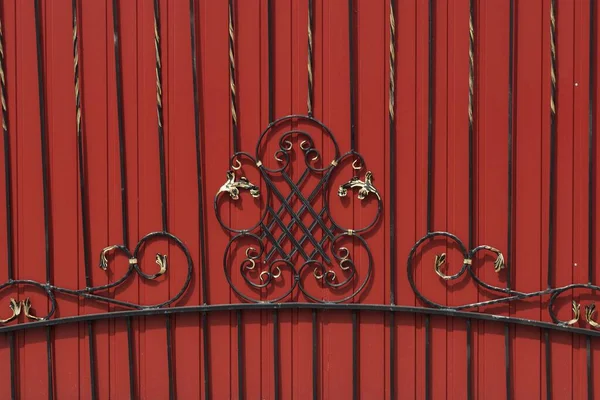 black red texture of iron forged rods in the pattern on the metal wall of the fence