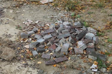 Doğada, kırılan gri tuğlalardan bir çöp yığını.