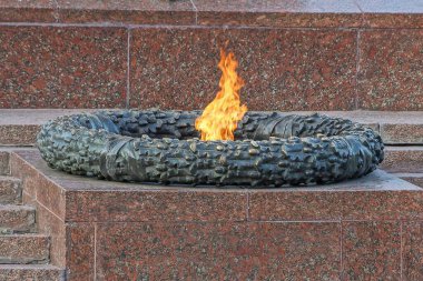 Granit kahverengi bir duvarın sonsuz alevi ve Odessa 'nın Ukrayna şehrindeki turuncu alevin etrafında bronz bir anıt.