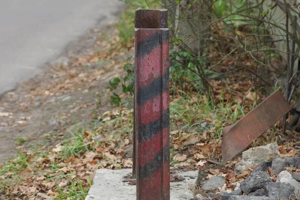 Ein Gestreifter Eisenstangenbegrenzer Auf Einem Grauen Betonklotz Auf Der Straße — Stockfoto